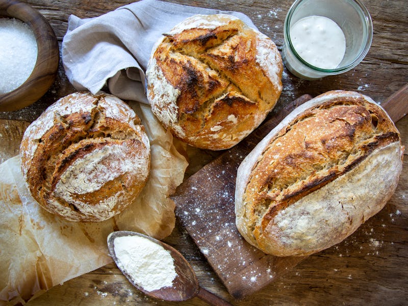 Loaf of rustic bread on old wooden table.