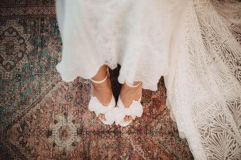 Fashionable woman getting dressed for her wedding with shoes with bows
