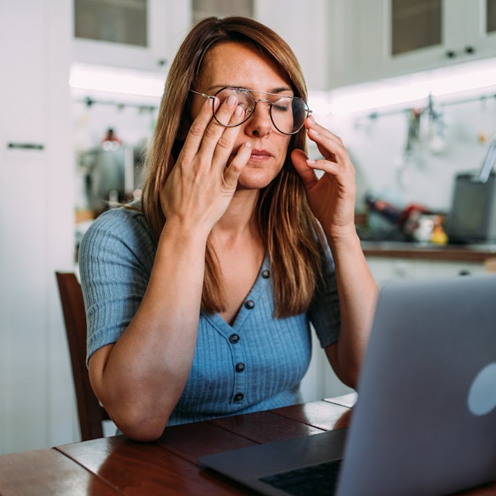Stressed woman working from home. Frustrated businesswoman with head in hands sitting on the desk at...