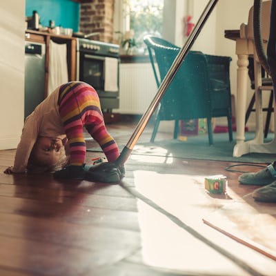 Mother cleaning while little girl getting tired.