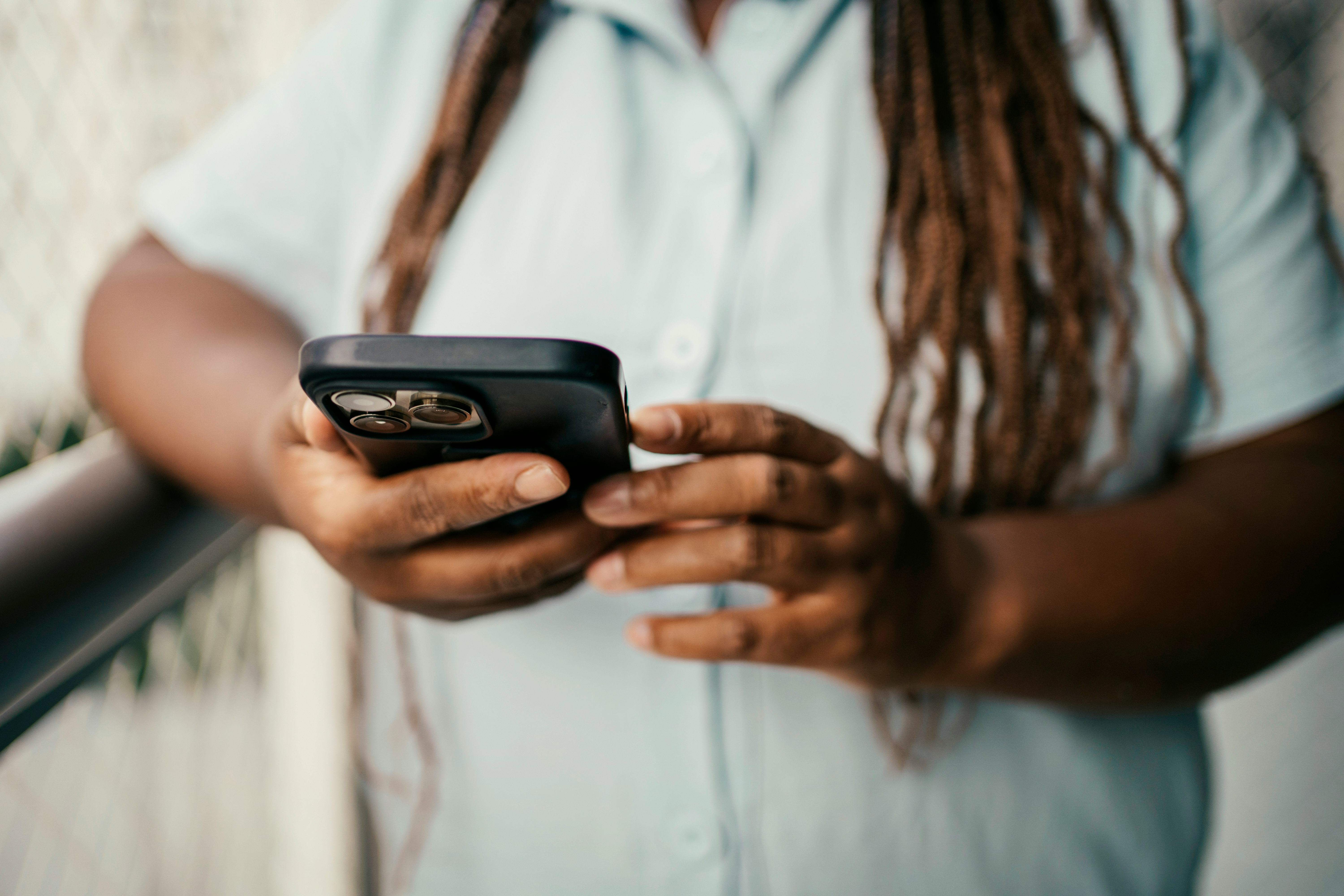 Black woman hands using smart phone at home