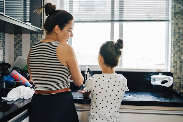 Mom and her adorable daughter washing the dishes while having conversations together