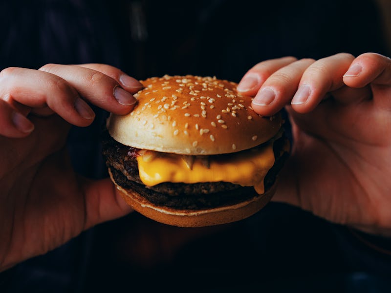 Man eating cheeseburger, close-up view