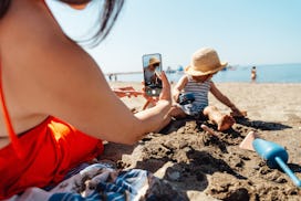 Young Asian mother and daughter having fun on the beach. Summer family vacation. Motherhood and well...