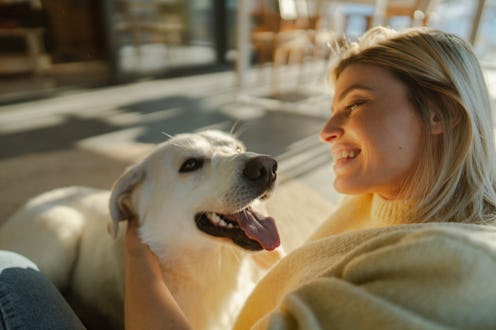 Photo of a young woman and her dog spending a winter day together in the cabin house