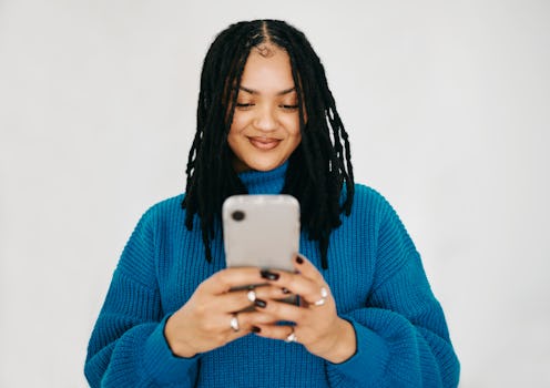 Happy Woman with Dreadlocks in Blue Sweater Texting with Copy Space