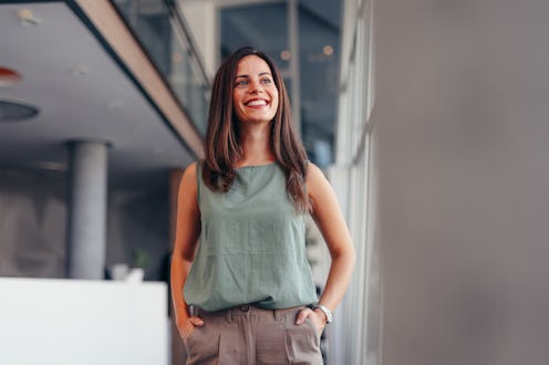 Waist up portrait modern business woman in the office looking away with copy space. Female executive...