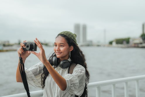 An Asian woman tourist exuding excitement while explores the vibrant streets of Bangkok City, and ca...