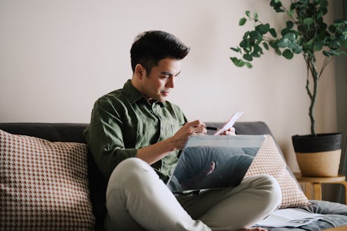Asian man planning family finances at home.