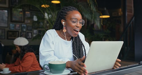 Coffee, black woman and surprise on laptop, smile and freelancer with shock in email, glasses and jo...
