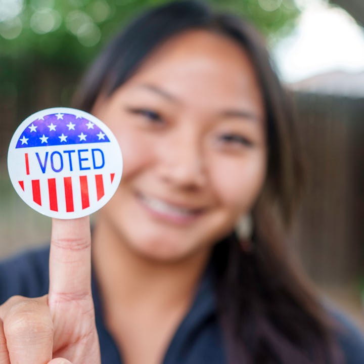 A woman proudly displays her I VOTED sticker. This election, 10 states are deciding upon important m...
