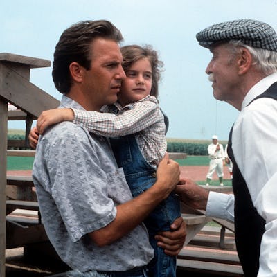 Kevin Costner holding Gaby Hoffmann in a scene from the film 'Field Of Dreams', 1989. (Photo by Universal/Getty Images)