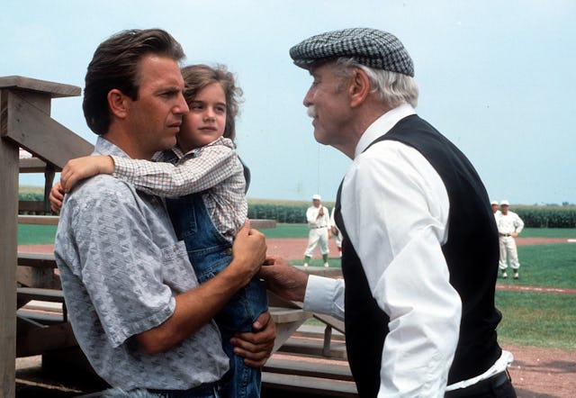 Kevin Costner holding Gaby Hoffmann in a scene from the film 'Field Of Dreams', 1989. (Photo by Univ...