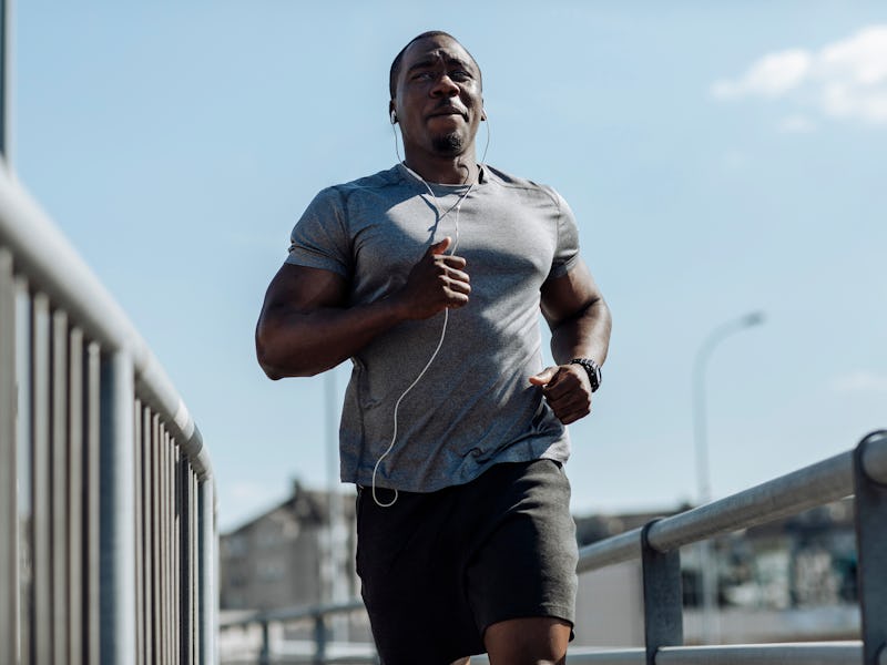 A young muscular man is running in the city
