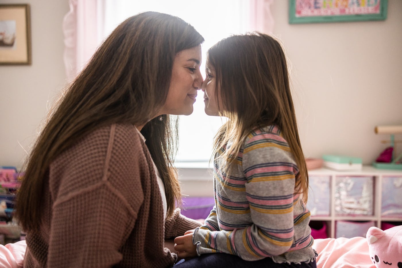 Mother and daughter cuddling on her bed