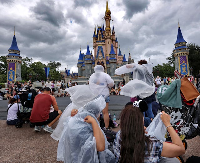 Guests at the Magic Kingdom break out ponchos at Cinderella Castle as bands of weather from Hurrican...