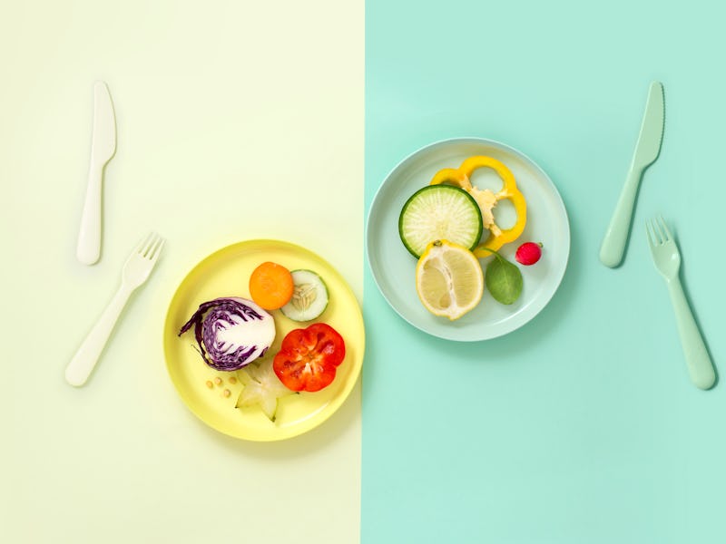 Minimalist style healthy eating colourful sliced vegan food served on coloured eating utensil in col...