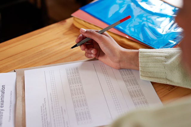 Hand of a teenage student during an exam. Massachusetts will vote to eliminate the MCAS as a state g...