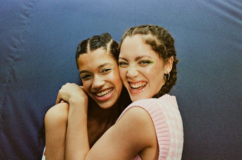 Happy female friends against blue backdrop