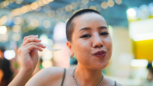 Asian young women vlogger use camera record vlog while travel in night market. Attractive girls tour...