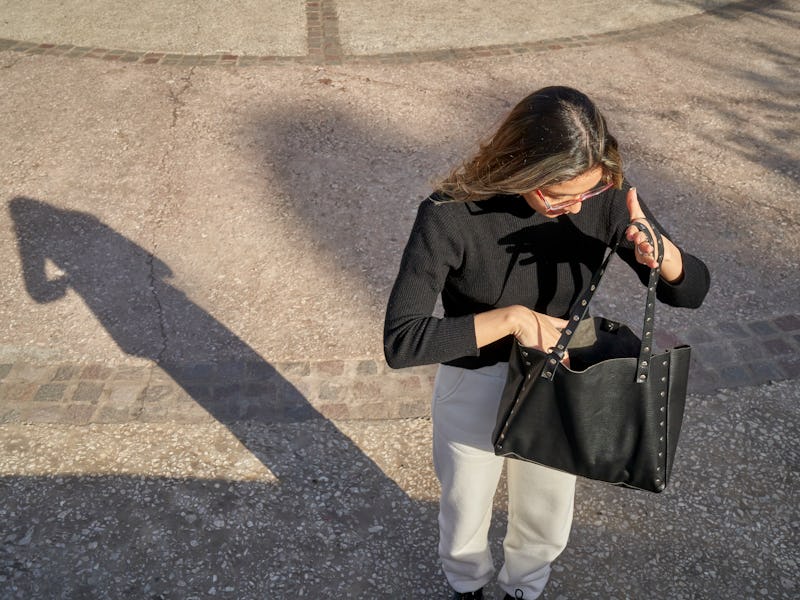 Forgetful Woman Looking for Something in Messy Purse