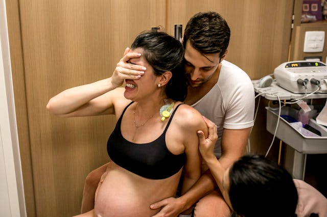 A woman in labor gets assistance from her partner and doula.