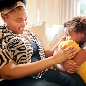 Mother consoling her sad daughter while sitting on sofa at home, in a story about what to do when yo...