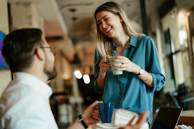 Businessman and businesswoman drinking coffee in the office. Colleagues on a coffee break.