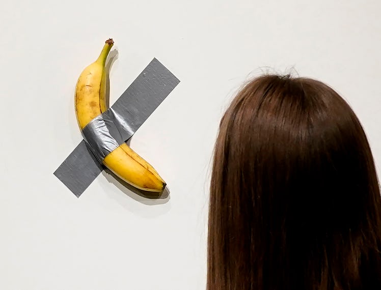 People look at Italian visual artist Maurizio Cattelan's duct-taped Banana entitled "Comedian," duri...