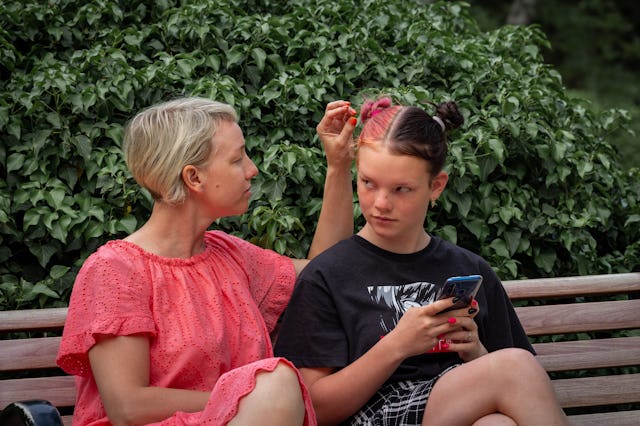 Conflict of caring single mother and a irritation teenage daughter in the park. Problems in the rela...