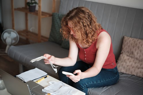 Cost of living crisis. Worried sad woman sitting at table looking at financial bills feeling stresse...