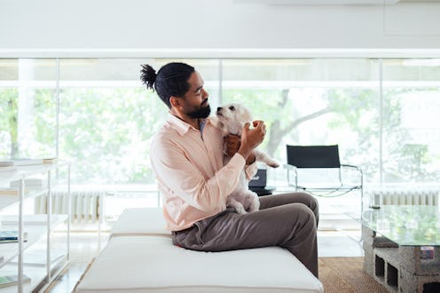 A man with a beard and his dog enjoying a peaceful moment in a modern, bright office.