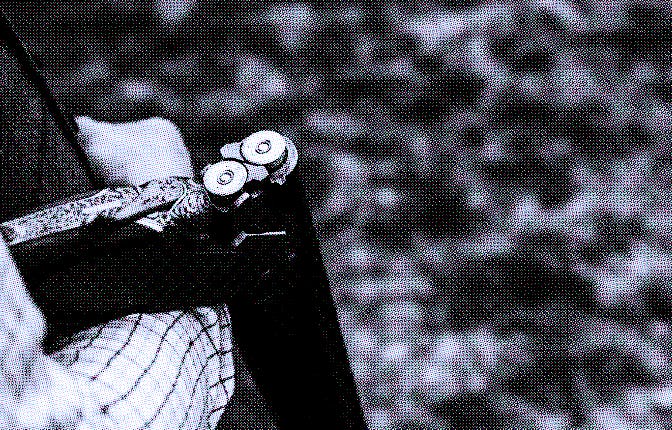 Close-up shot of an open shotgun barrel with shotgun cartridges in it. The man's arm is visible as t...