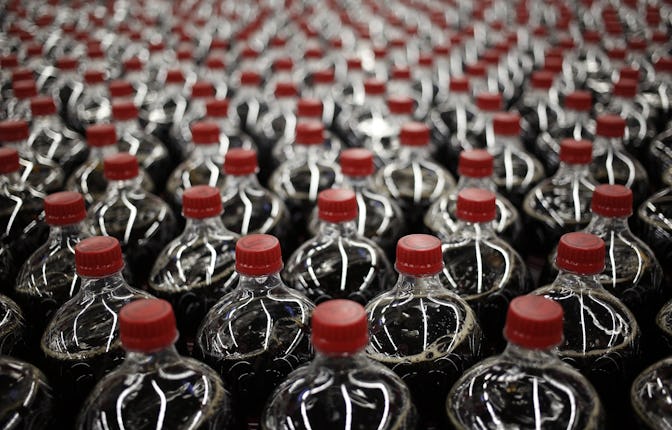 Two liter bottles of Dr. Pepper brand soda move down a conveyor belt after being filled at the Dr. P...