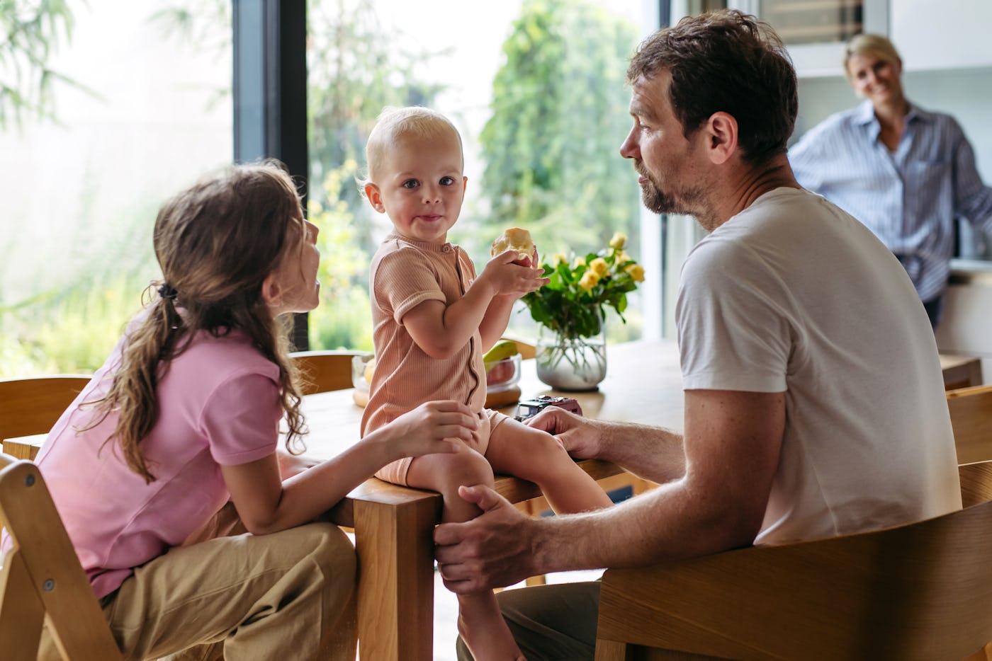 Young family sitting in the kitchen, eating. Nuclear family spending Sunday morning at home.