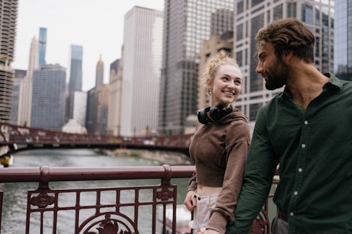 Happy couple communicating while walking on the bridge in the city.