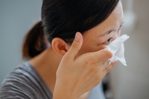 Young asian woman removing makeup with makeup remover wipe