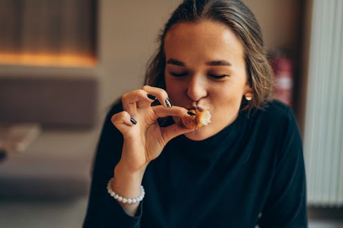 A relaxed scene featuring a young woman sipping coffee and savoring a croissant in a cozy café. The ...