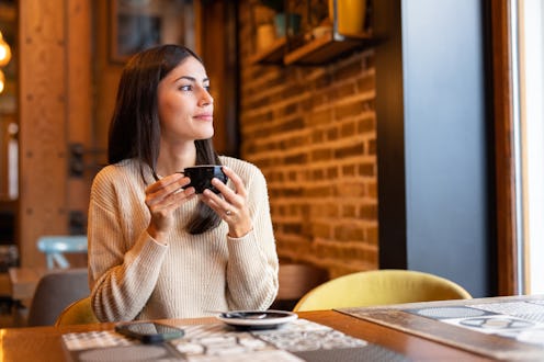 Woman having coffee in restaurant.