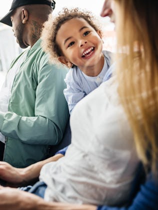 A family shares a lighthearted moment in the airport seating area, with a child's laughter setting t...