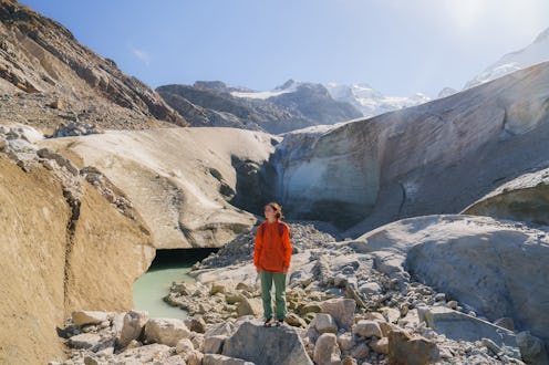 Woman with backpack exploring glacier in Swiss Alps