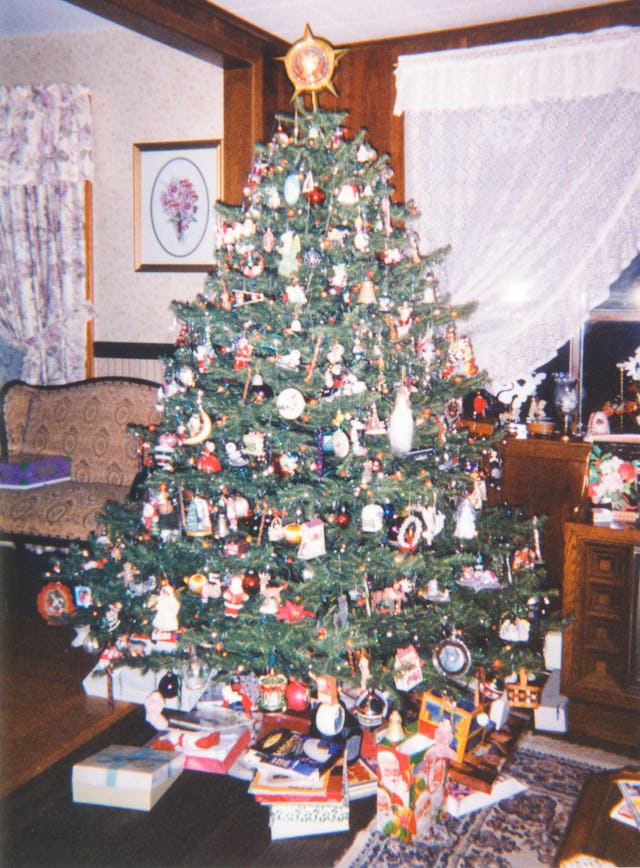 Vintage 1990s Christmas tree with Christmas presents under tree. Cozy home concept for gifts, nostal...