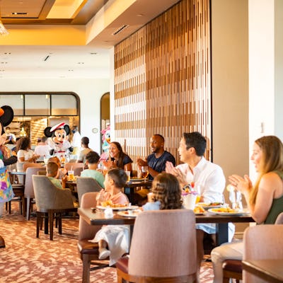 LAKE BUENA VISTA, FL - JUNE 23: In this handout photo provided by Walt Disney World Resort, guests at Disney's Riviera Resort see Mickey Mouse, Minnie Mouse, Donald Duck and Daisy Duck during breakfast at Topolino's Terrace Flavors of the Riviera, the resorts rooftop restaurant on June 23, 2020 in Lake Buena Vista, Florida. During the phased reopening, characters maintain proper physical distancing while parading through the restaurant during mealtimes. Walt Disney World Resort theme parks begin their phased reopening on July 11, 2020. (Photo by Matt Stroshane/Walt Disney World Resort via Getty Images)