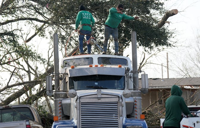 KATY, TEXAS DECEMBER 28: Workers remove tree limbs from the top of a truck following a a tornado o...