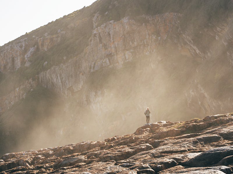 A female tourist walks along the coast in Robberg Game Reserve in South Africa.