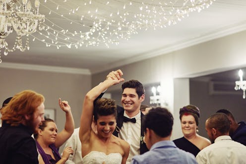Shot of a young couple dancing with their friends at their wedding reception