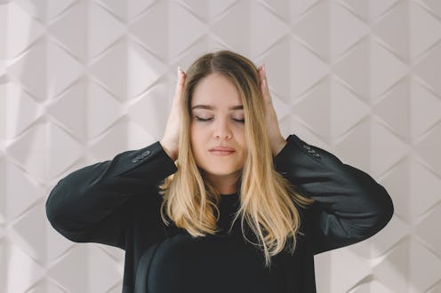 Woman covers her ears with her hands
