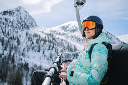Woman sitting on the ski lift high in the Alps, enjoying the calm and relaxing views, getting ready ...