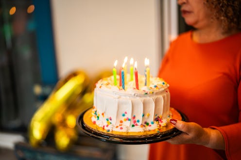 Close-up of woman holding cake during birthday party at house