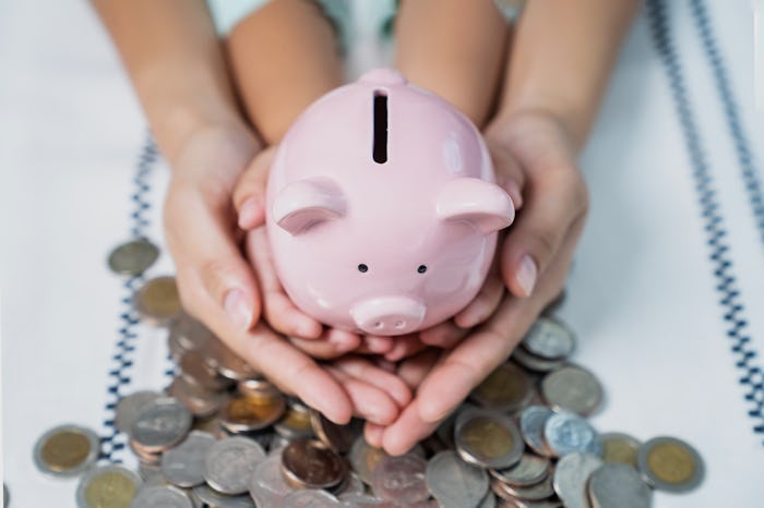 Mother and baby girl putting money in college fund